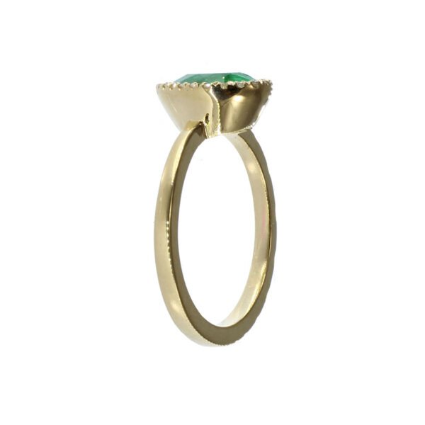 Anillo artesanal de oro 18k con esmeralda colombiana y diamantes Anillo de oro 18k con esmeralda colombiana en forma de lágrima rodeada de diamantes naturales lateral