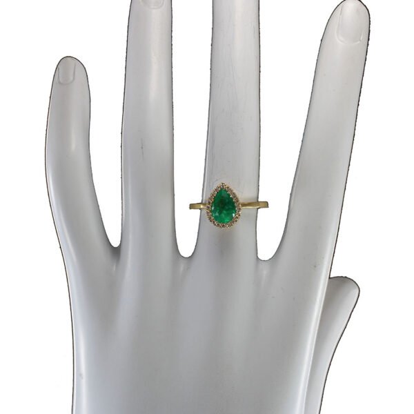 Anillo artesanal de oro 18k con esmeralda colombiana y diamantes Anillo de oro 18k con esmeralda colombiana en forma de lágrima rodeada de diamantes naturales perfil